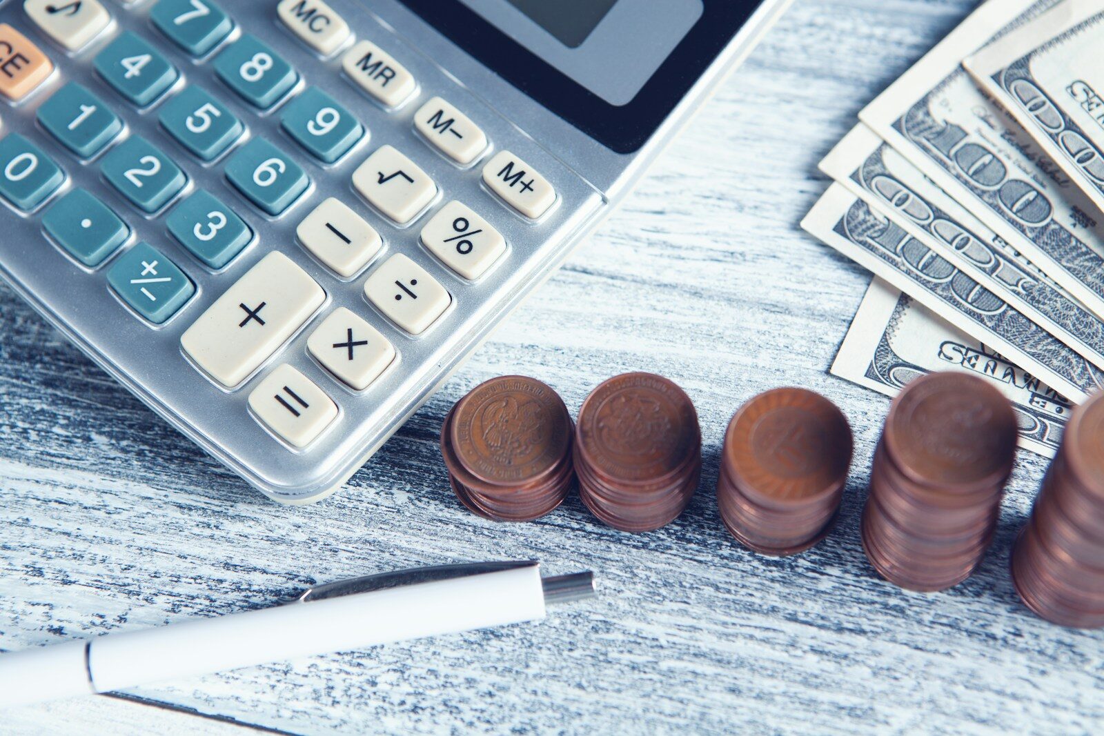 Calculator and stacked coins on a desk representing a small Facebook ads budget