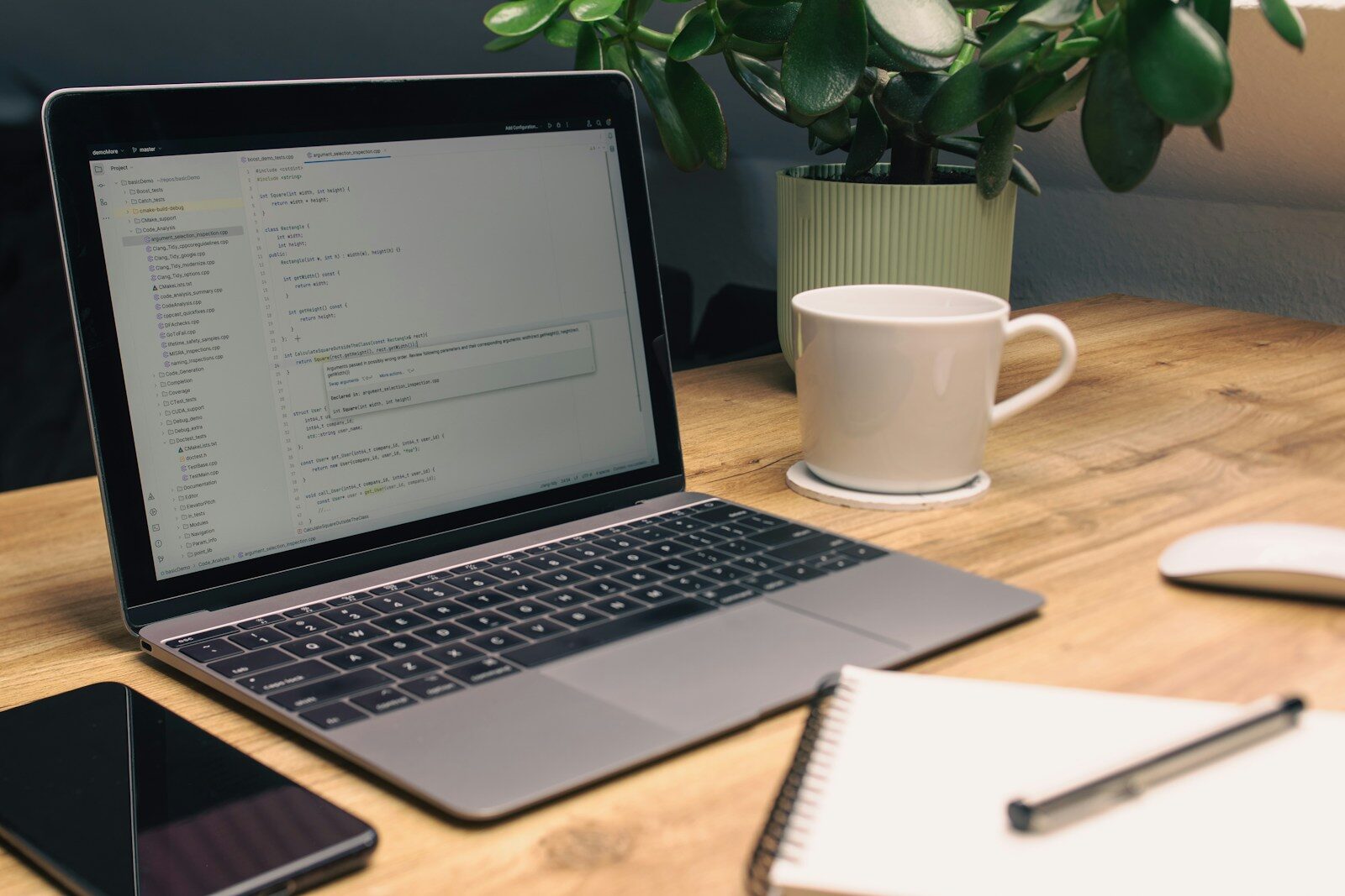 Laptop open on a desk with notes and coffee, drafting ad copy prompts